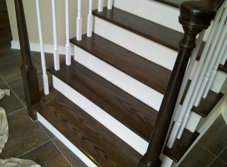 brown and white stairs with white railings of a house with beige walls